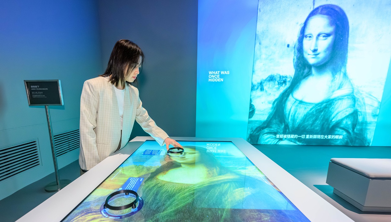 A woman using immersive technology to learn more about the Mona Lisa.