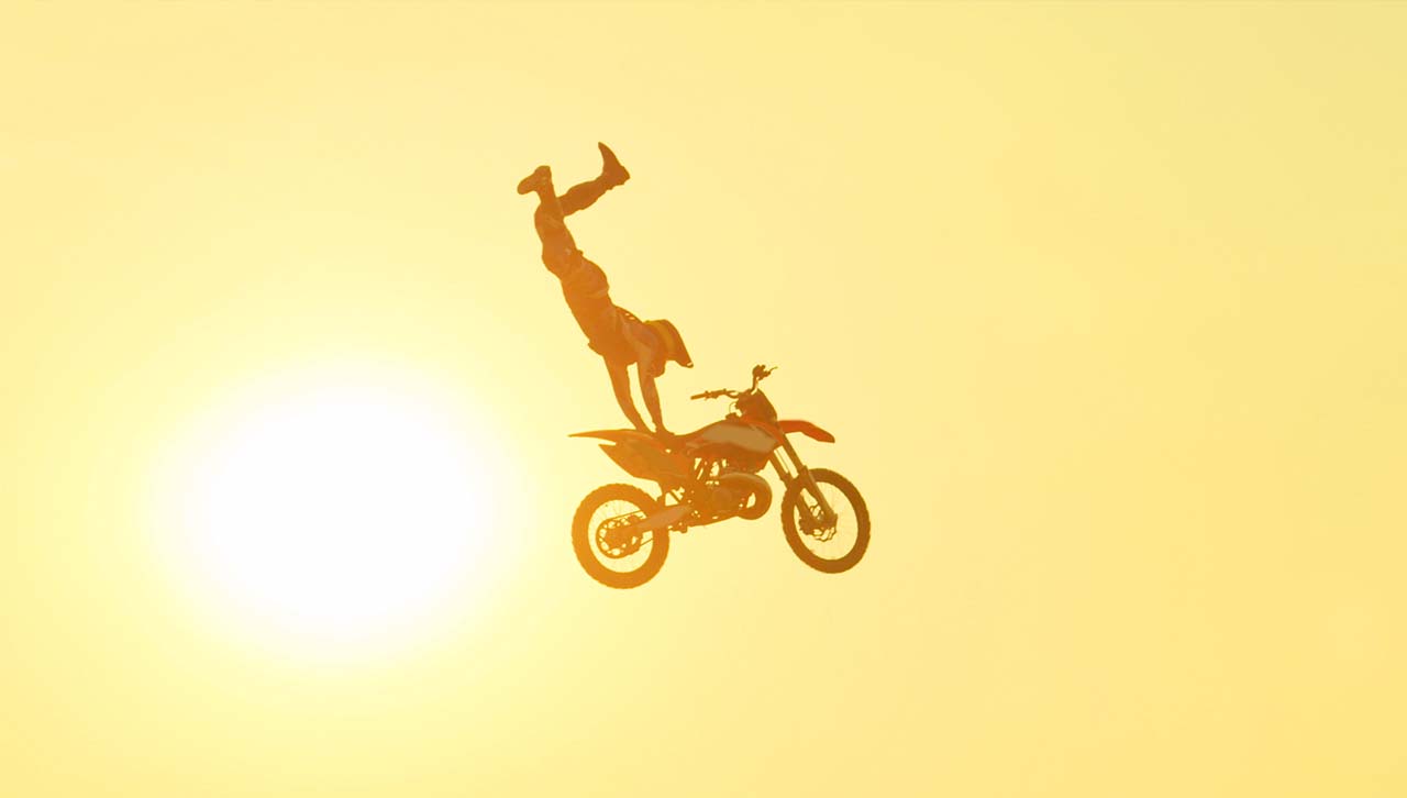 A man doing a superman seat grab on a motorbike jump