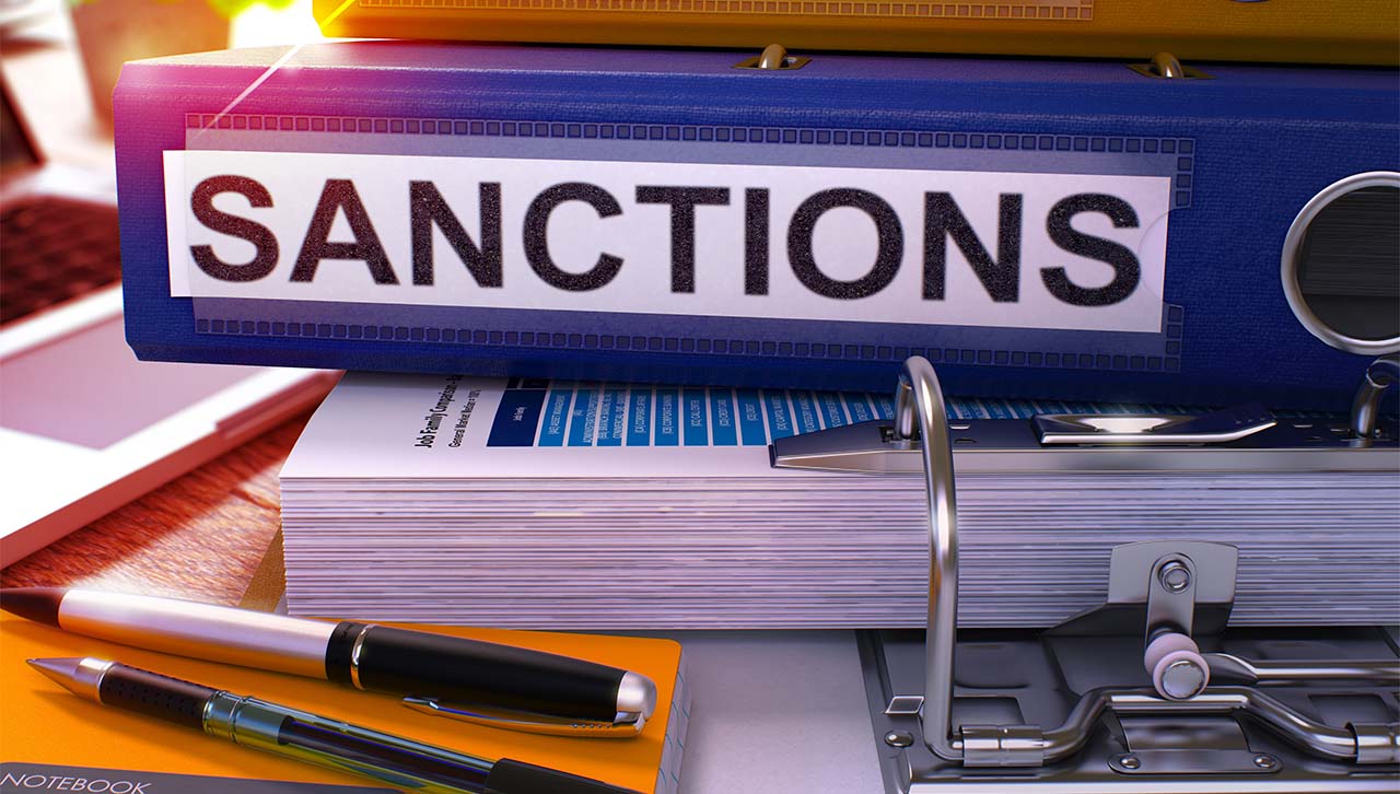 A folder with the word "SANCTIONS" on the side